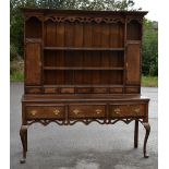 An early 19th century oak and mahogany crossbanded dresser, the invert breakfront moulded cornice