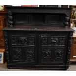 A large Victorian carved oak court cupboard, the raised upper section with twin cupboards doors