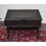 A Victorian carved oak square sectioned lidded box, now mounted as a table on outswept supports,