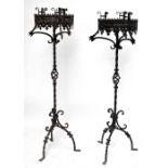 A pair of contemporary wrought iron and pressed metal Gothic inspired candle stands with wrythen