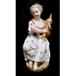 MEISSEN; a mid 19th century figure of a seated female playing the pipes, painted mark to base,