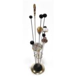 CHARLES HORNER; a hat pin stand set with eleven hat pins including a micromosaic domed example,