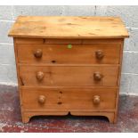 A pine chest of three long drawers with slightly bowfronted top and raised on integral bracket feet,