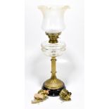 An early 20th century brass oil lamp with cut glass reservoir and later frosted glass shade,