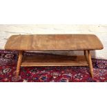 ERCOL; a medium elm rectangular coffee table with spindle magazine rack undertier, raised on