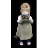 MEISSEN; a 20th century figure of a child drinking from a cup with toy horse by their side,