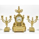 An early 20th century gilt metal three piece clock garniture, the clock with urn surmounts above