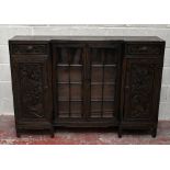 An early to mid 20th century Chinese carved hardwood inverted break front display cabinet, with