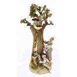 MEISSEN; an early 20th century figure group of a figure picking apples in an apple tree with three