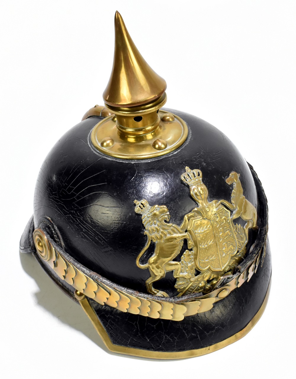 A Prussian WWI leather pickelhaube with applied brass plaque inscribed ‘Furchtlos und trew’, with