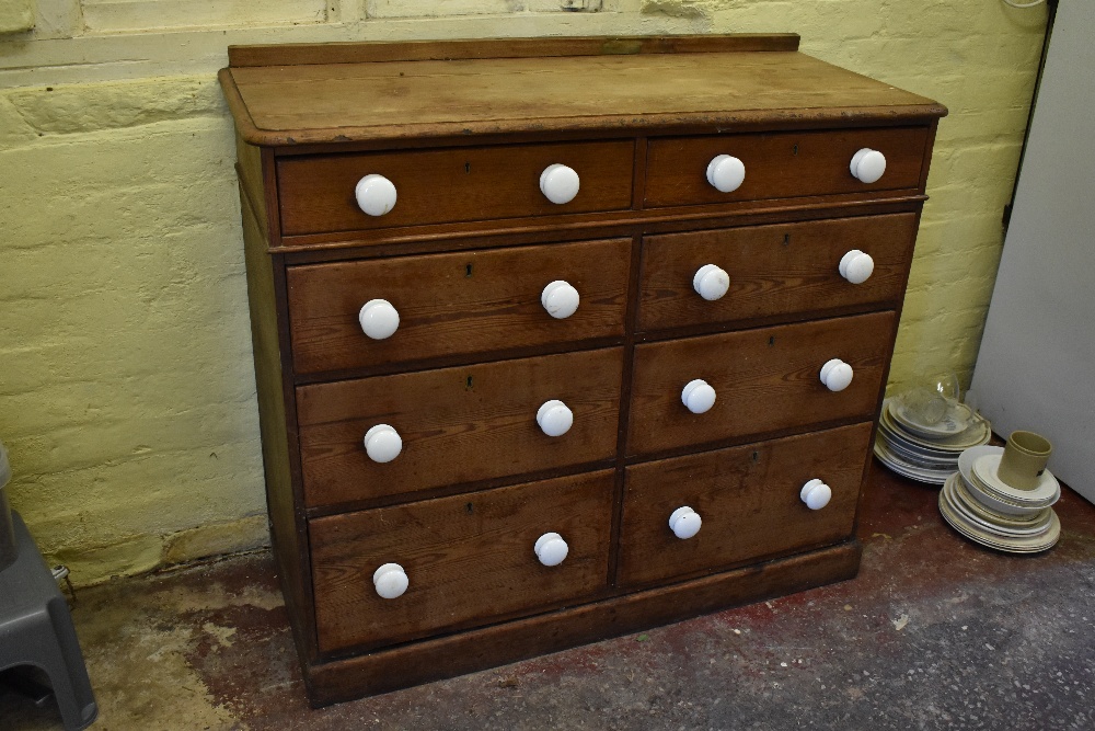 A Victorian pine chest of two rows of four graduated long drawers, with ceramic handles, on plinth