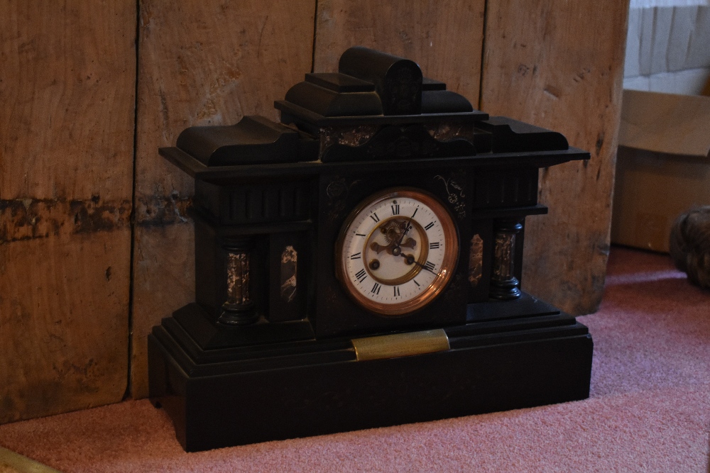 A Victorian eight day black slate mantel clock, with enamelled chapter ring with Roman numerals