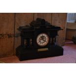 A Victorian eight day black slate mantel clock, with enamelled chapter ring with Roman numerals