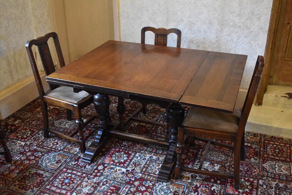 A 1930s oak draw-leaf dining table, with baluster legs on standard end supports, height 76cm,