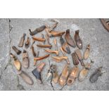 A collection of twenty-seven vintage treen shoe lasts and shoe moulds, including a pair with leather