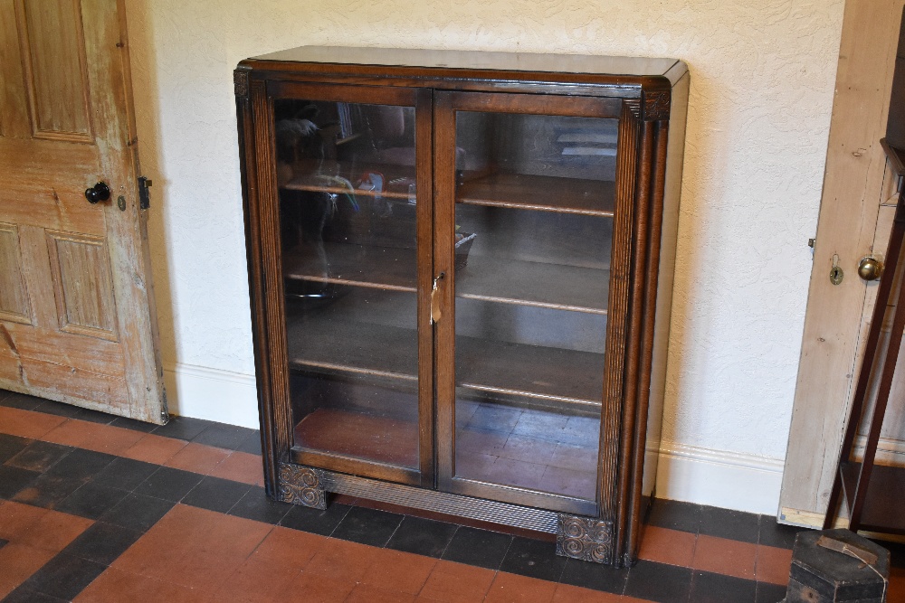 A 1930s Continental Art Deco oak two door display cabinet, on bracket feet, height 119cm, width