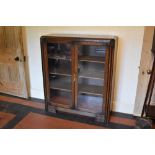 A 1930s Continental Art Deco oak two door display cabinet, on bracket feet, height 119cm, width