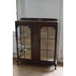 A 1930s walnut two door display cabinet, on cabriole legs, height 108cm, width 100cm, depth 33cm.