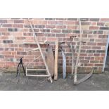 A vintage wood and iron hay rake / gatherer, an ash handled scythe, hay knife, an iron tripod and an