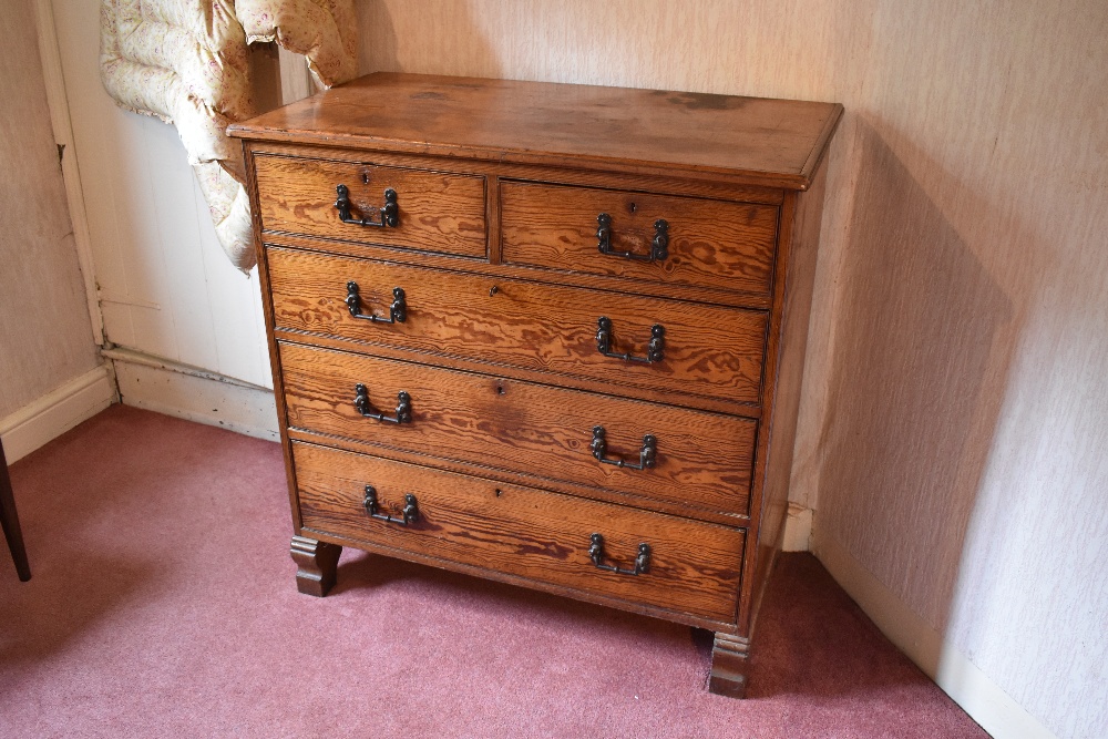 A late Victorian pitch pine chest of two short and three long drawers, on carved block feet,