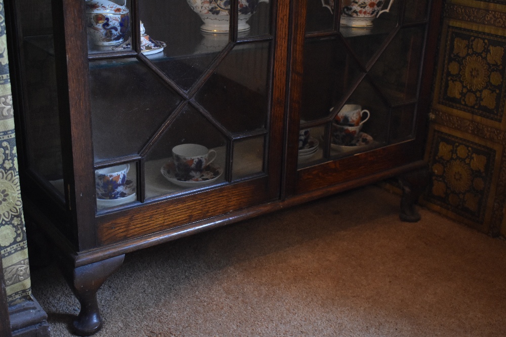 A 1920s oak display cabinet, with two astragal glazed doors enclosing glass shelves, on cabriole - Bild 3 aus 3