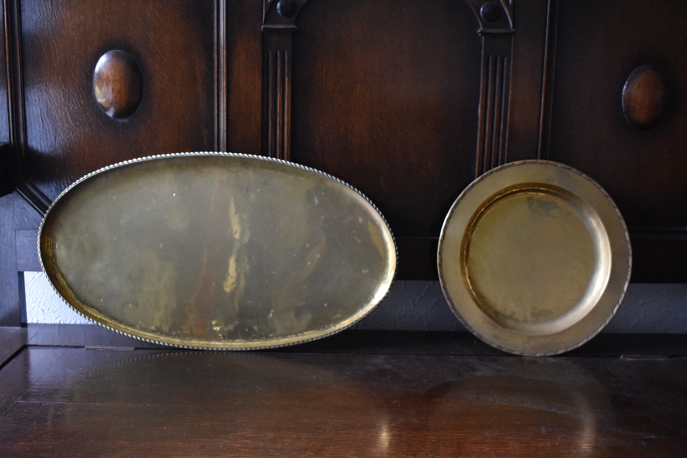 HUGH WALLACE; two brass dishes, one circular, diameter 28.5cm, and one oval, length 52cm, both