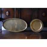 HUGH WALLACE; two brass dishes, one circular, diameter 28.5cm, and one oval, length 52cm, both