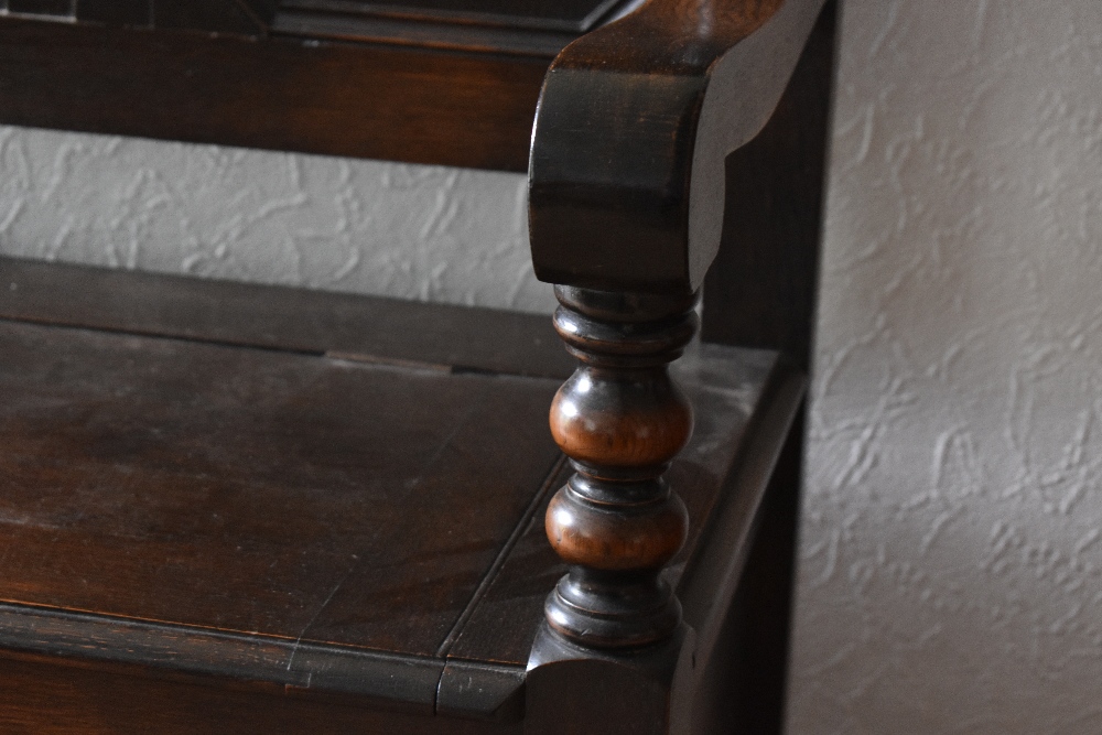 A 1920s oak settle, with panelled back and box seat, on turned feet, height 113cm, width 121cm, - Bild 3 aus 3