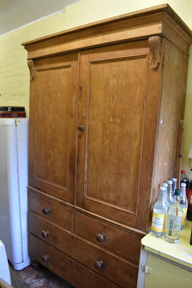 A Victorian pine housekeeper's cupboard, with two panelled cupboard doors enclosing shelves above