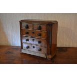 A late Victorian mahogany miniature apprentice chest, with two short and three long drawers, on disc