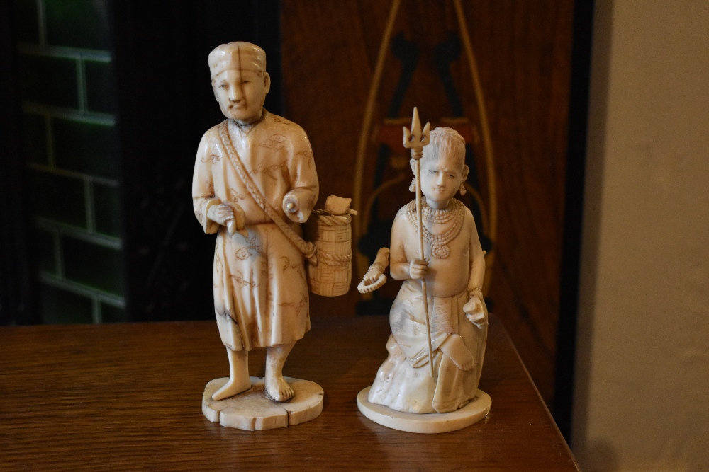 An early 20th century Japanese carved ivory figure of a gentleman pedlar, on oval base, and an early