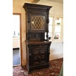 A late 19th century French carved and stained oak cabinet, the upper section with a replacement lead