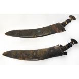 A pair of kukris with bone inlaid carved handles within leather scabbards with applied pressed