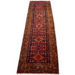 A hand knotted red ground Persian runner,