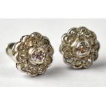 A pair of diamond cluster stud earrings with central collet set small brilliant cut diamond within