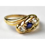 A 9ct gold cross over ring set with two white sapphires and a blue sapphire .