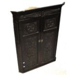 An early 19th century oak wall-hanging corner cupboard,