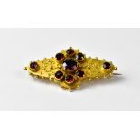 A 15ct yellow gold brooch set with eight garnets, approx 6g.