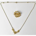 A 15ct gold articulated pendant set with small seed pearls, on a yellow metal chain,