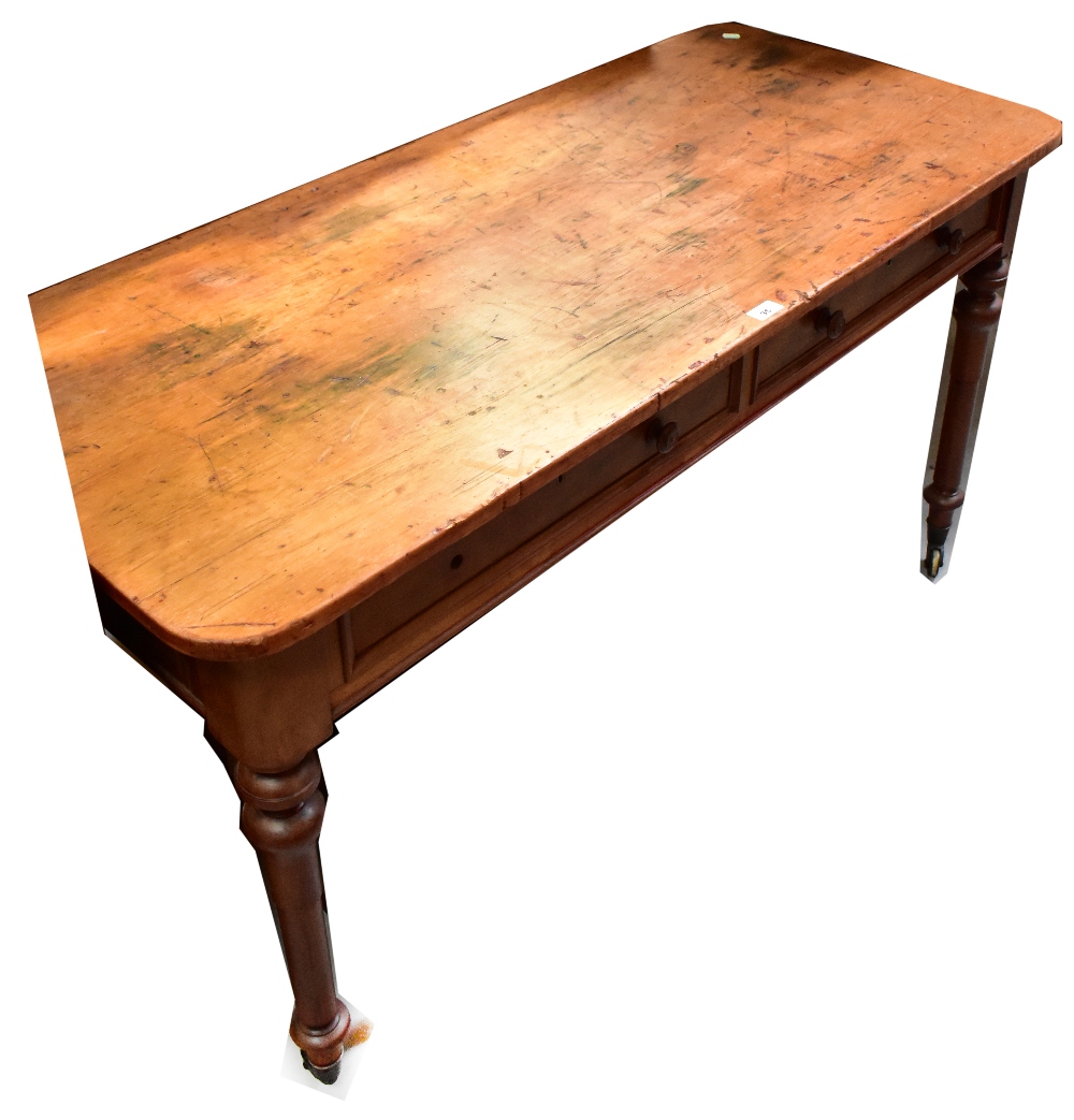 An early 20th century rectangular topped schoolroom writing table, top with ink marks and graffiti,