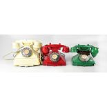 Three vintage Bakelite telephones, a red example, the central tab with a Wrexham 3505 number,