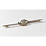 A yellow and white metal bar brooch with florally diamond set centre within a scrolling decoration,