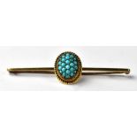 A 14ct gold bar brooch with a centred oval containing a cluster of small turquoise beads, length 5.