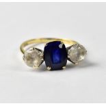 A 9ct yellow gold ring set with central oval blue stone and white stone to either side, size Q,