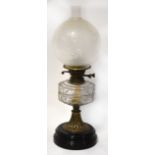 A 19th century paraffin lamp, the clear glass font with moulded square pattern,