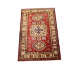 A 20th century Middle Eastern rug with geometric patterns, square floral panels,