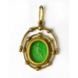 A late 19th/early 20th century green intaglio depicting a seated Eros with wings and bow and arrow,