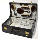 A large black vanity travel case with frilled satin pockets to the inside,