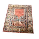 A modern Middle Eastern square prayer rug with red ground and a wide outer square floral border,