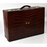 An early 20th century crocodile vanity suitcase, brown with gilt initials to the lid, 'MP',